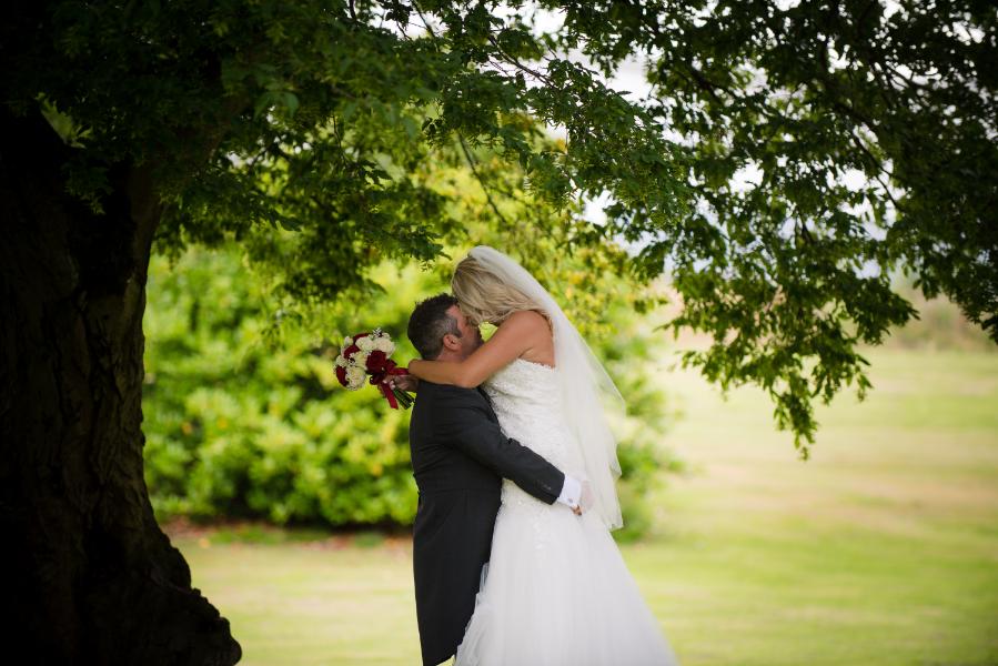 Bride and groom under tree at Eastwood Hall wedding